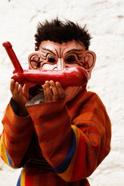 Close-up of an atsara's red mask with bulbous nose and wide grin