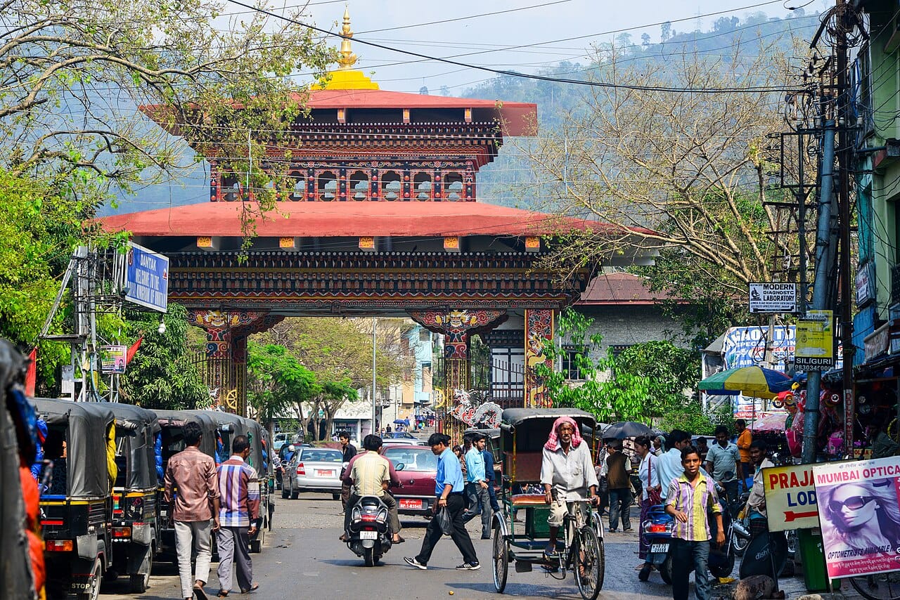The ornate Bhutan Gate seen from a busy Jaigaon street with rickshaws